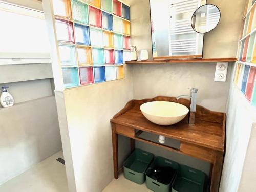 La salle de bains est pourvue d'un lavabo et de vitraux. dans l'établissement Maison du garde barrière - Atypique et chaleureuse, à Évian-les-Bains