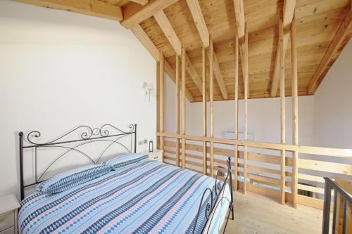 - une chambre avec un lit dans une pièce dotée de plafonds en bois dans l'établissement La Corte di Nonna Gemma - Holiday Home, à Delebio