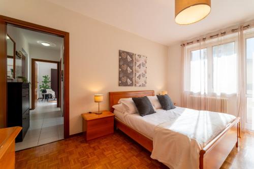 - une chambre avec un lit et une grande fenêtre dans l'établissement Scarlet Apartment with Garden by Wonderful Italy, à Magreglio
