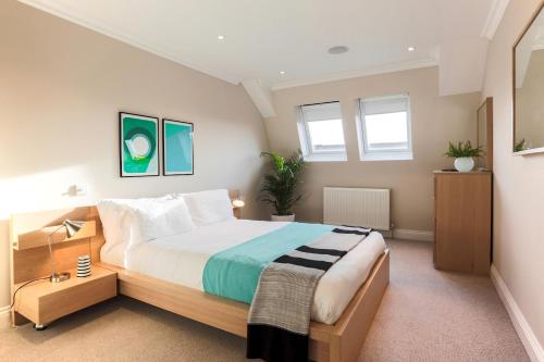 sypialnia z dużym łóżkiem i 2 oknami w obiekcie Madison Hill - White Hill House 5 - 3 bedroom flat w Londynie