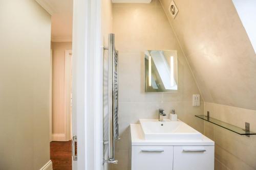 a bathroom with a sink and a mirror at Madison Hill - White Hill House 5 - 3 bedroom flat in London