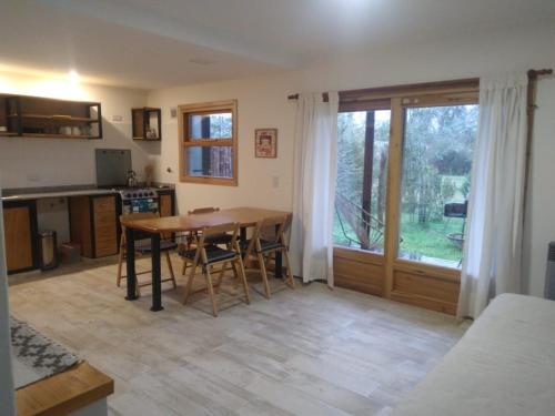 Una cocina y un comedor con una mesa de madera. en Mebruck Lago Puelo, en Lago Puelo