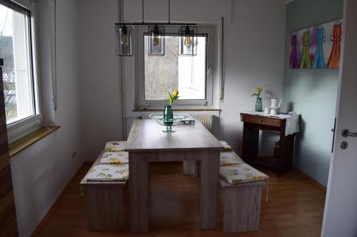 a room with a table with a bench and two windows at Hunsrück in Schauren