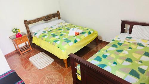 a bedroom with two beds and a night stand at Balcones del Paraíso in Baños