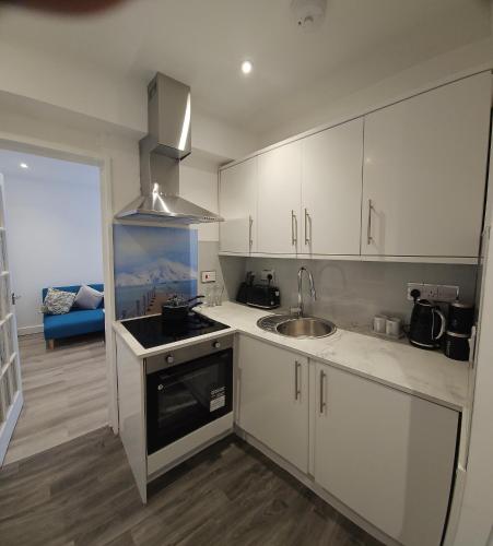 a kitchen with white cabinets and a sink at Brand New Private Annex Guest Suite in Chandlers Ford