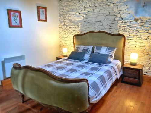 una camera da letto con un grande letto e un muro in pietra di Gite La Haye d'Armor a La Tiolais