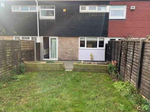 a fence in front of a house with a white door at Impeccable 3-Bed House in Birmingham in Birmingham