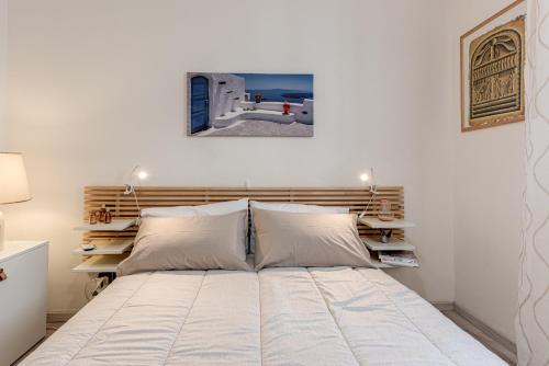 a bedroom with a large bed with white sheets at Nel cuore del rione del Drago in Pistoia