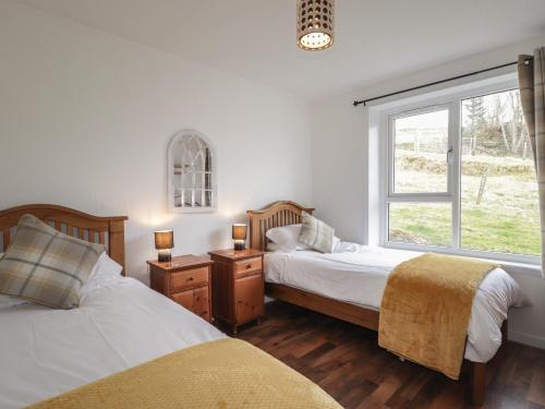 a bedroom with two beds and a window at Taigh Neilag in Elgol