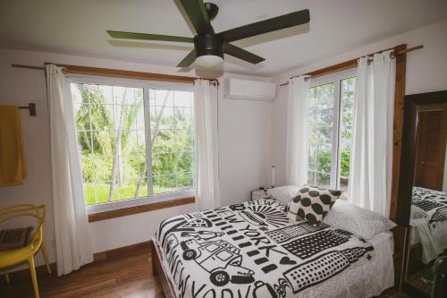una camera con letto e ventilatore a soffitto di Luna Beach Luxury Boutique Beach Front Resort a Roatán