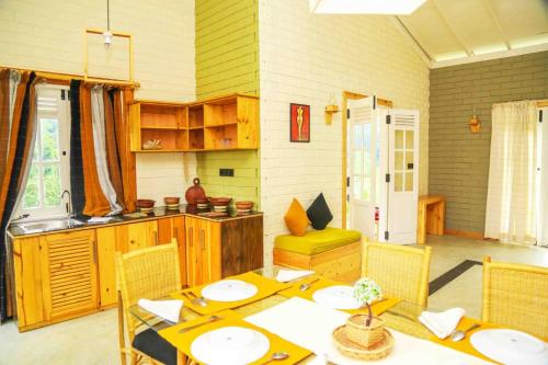 a dining room with a table and a kitchen at Global Gateway in Kananke