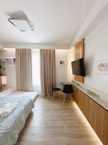 a hotel room with two beds and a desk at UNIT B218 in Bacolod