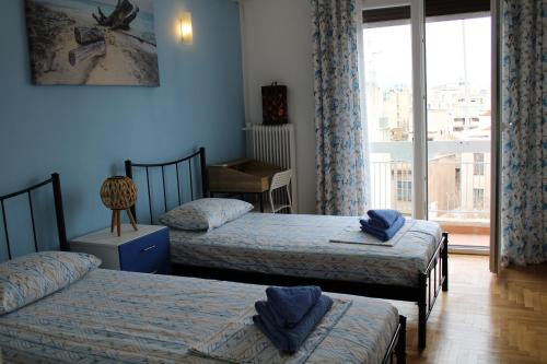 sypialnia z 2 łóżkami pojedynczymi i oknem w obiekcie Mona Hause w Atenach