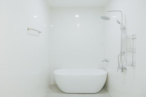 a white bathroom with a tub and a sink at Private 3BR Pool House Near Pattaya Beach in Ban Huai Yai