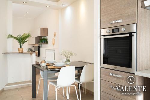 eine Küche und ein Esszimmer mit einem Tisch und einem TV in der Unterkunft Viareggio - Via Pisano 61 Valente Italian Properties in Viareggio