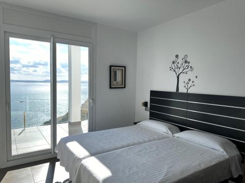 um quarto com uma cama grande e uma janela grande em Agi Joan Margarit em Roses
