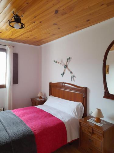 a bedroom with a bed and a cross on the wall at Les Eres de Gátova in Gátova