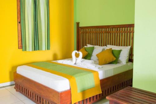 una camera con letto e pareti gialle e verdi di Hotel Niwahana a Udawalawe