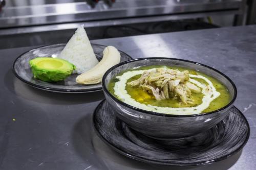 eine Schüssel Suppe auf einem Tisch mit einem Teller Essen in der Unterkunft Zoi Eco Hotel in Manizales