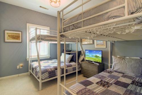 a bedroom with two bunk beds and a television at Pure Joy by AvantStay Beach Home w Amazing Views Community Pool in Isle of Palms