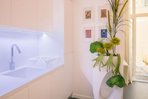 a bathroom with a sink and a vase with flowers at Apartament with a terrace in the heart of Lisbon, 300 in Lisbon
