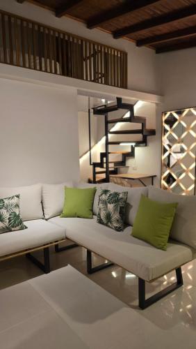 a living room with a white couch with green pillows at 'SELECT' Medellin in Medellín