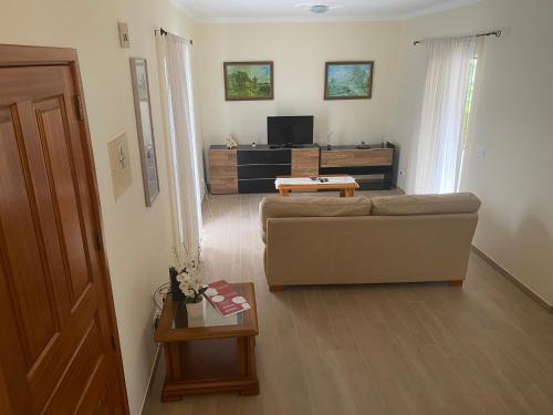a living room with a couch and a tv at The Vista House in Ponta Delgada