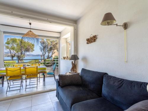 a living room with a couch and a table and chairs at Apartment L'Estelan-1 by Interhome in Le Lavandou