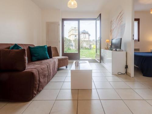 un salon avec un canapé et une télévision dans l'établissement Apartment Le Vert Clos by Interhome, à Villers-sur-Mer