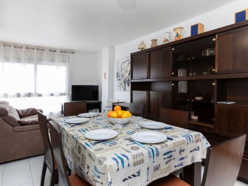 una cocina con una mesa con platos y naranjas. en Apartment Emporda-1 by Interhome en Llança