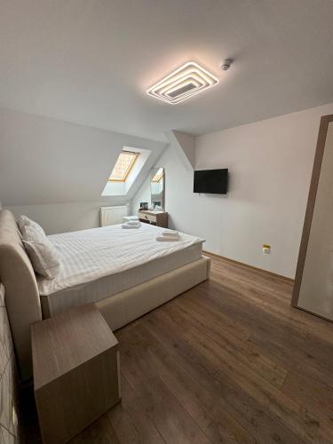 a bedroom with a bed and a television in it at Pensiunea Korona in Miercurea-Ciuc