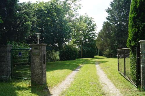 einen Garten mit einem Tor und einem Grasfeld in der Unterkunft Idylisches Cottage mit Reh in Wörthsee