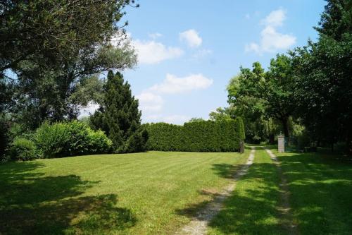 a large grass field with trees and a path at Idylisches Cottage mit Reh in Wörthsee