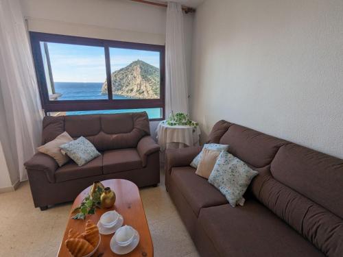 - un salon avec deux canapés et une vue sur l'océan dans l'établissement Apartment Cala Blanca by Interhome, à La Cala de Finestra