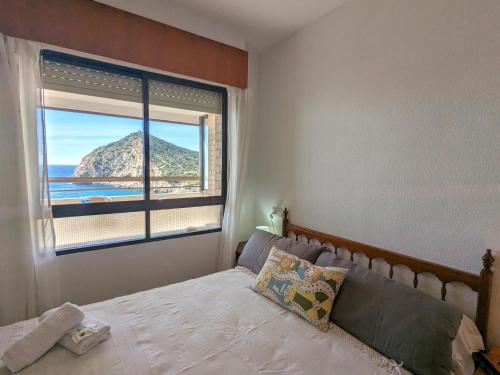 - une chambre avec un lit et une grande fenêtre dans l'établissement Apartment Cala Blanca by Interhome, à La Cala de Finestra