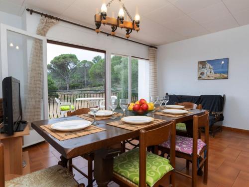 a dining room with a table with chairs and a television at Apartment Sarnella by Interhome in Llança