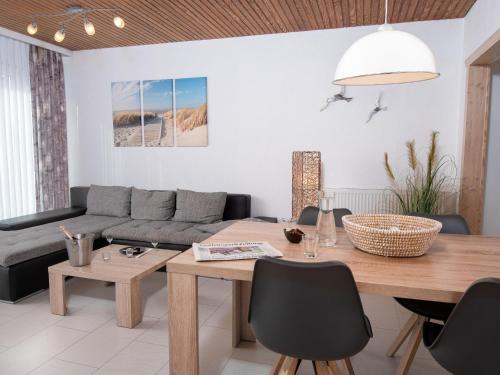 salon ze stołem i kanapą w obiekcie Holiday Home Sonnenschein by Interhome w mieście Norddeich
