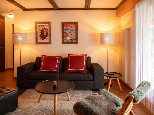 ein Wohnzimmer mit einem Sofa und roten Kissen in der Unterkunft Apartment Opale 4 by Interhome in Villars-sur-Ollon