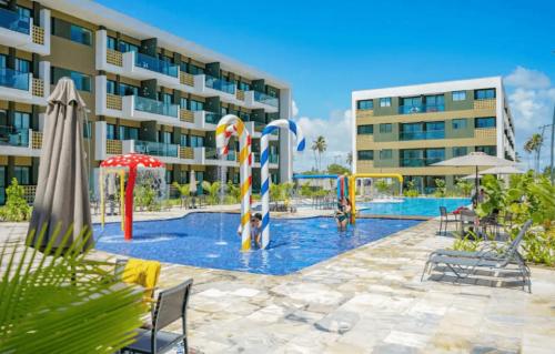 une piscine en face d'un bâtiment dans l'établissement Studio Deluxe Térreo Porto de Galinhas Mana Beach 350m do mar, à Porto de Galinhas