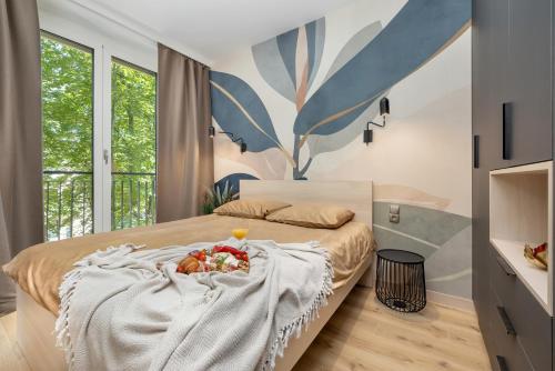 a bedroom with a bed with a tray of fruit on it at Wyspa Uznam Promenada Seaside Garden in Świnoujście