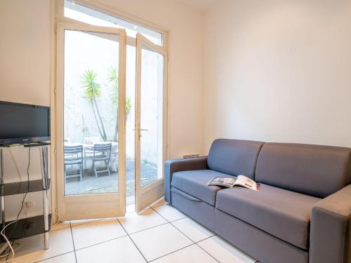 un salon avec un canapé et une porte coulissante en verre dans l'établissement Apartment Legallais by Interhome, à Arcachon
