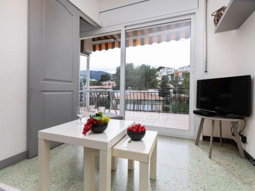 sala de estar con mesa blanca y TV en Apartment Gran Sol by Interhome, en Llançà