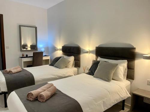 a bedroom with two beds with towels on them at Spacious and Cozy Apartment near St Julians - Short Let Apartments Malta in Is-Swieqi