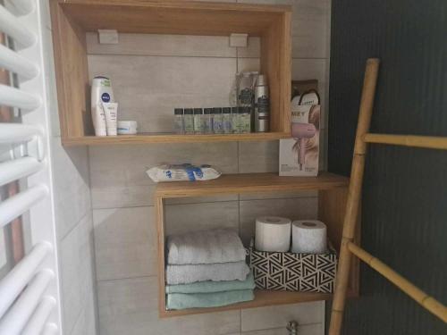 La salle de bains est pourvue d'étagères en bois et de serviettes. dans l'établissement Apartman Tošić, à Trnava