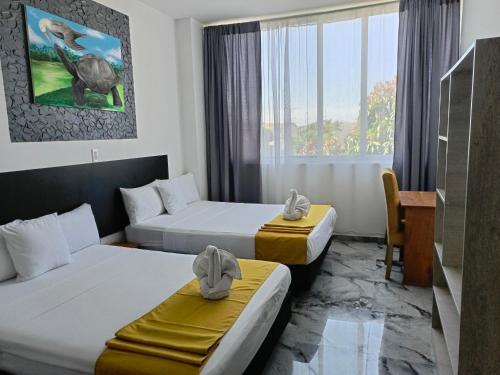 Cette chambre comprend deux lits et un bureau. dans l'établissement Patty House Galapagos, à Puerto Ayora