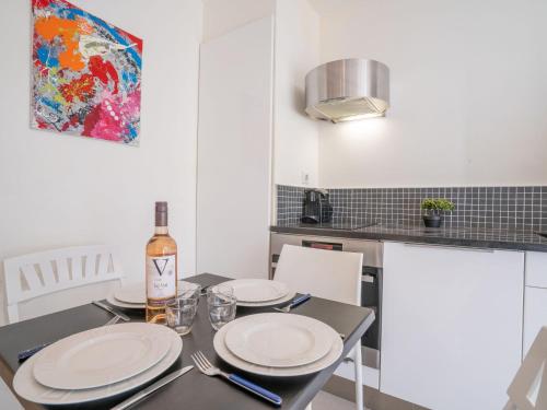 - une table à manger avec des assiettes et une bouteille de vin dans l'établissement Studio Les Pieds dans l'eau by Interhome, à Arcachon