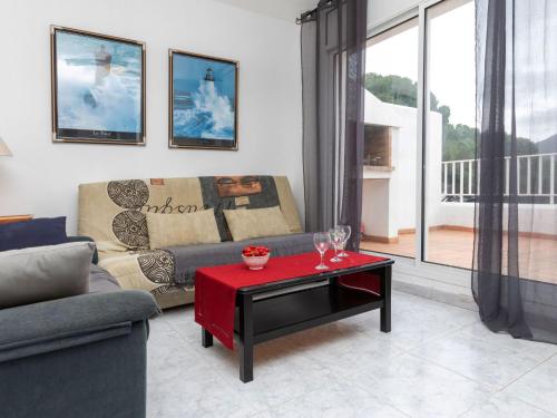 a living room with a couch and a red table at Holiday Home El Morer by Interhome in Llança