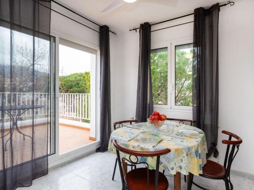 a dining room with a table and chairs and a balcony at Holiday Home El Morer by Interhome in Llança