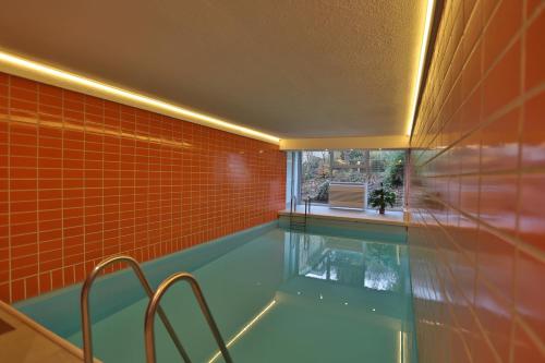 una piscina con azulejos de color naranja y una ventana en Haus Adria Haus Adria Appartement 29, en Scharbeutz