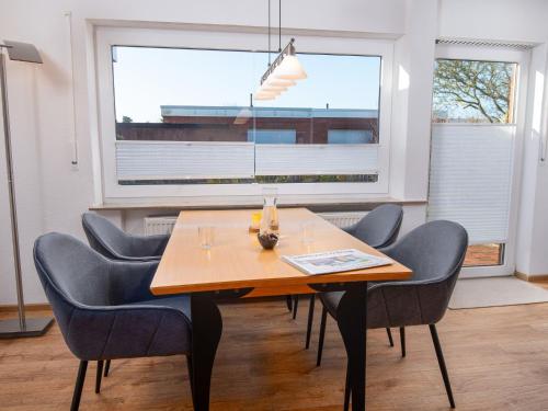una sala da pranzo con tavolo, sedie e finestra di Holiday Home Kotthaus by Interhome a Norddeich